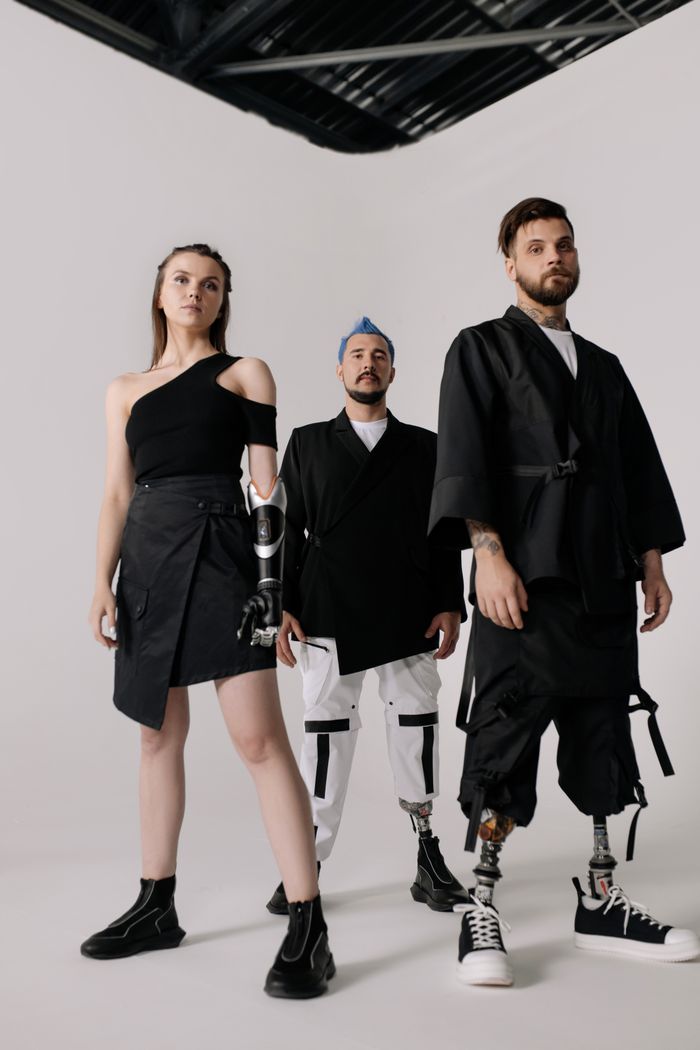 Group of models showcasing modern prosthetic fashion indoors.