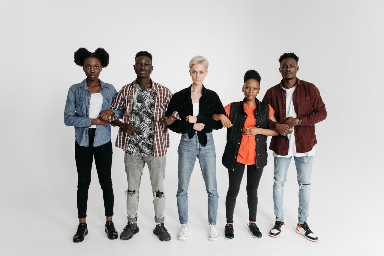 A diverse group of young adults united and holding hands, symbolizing solidarity and activism.